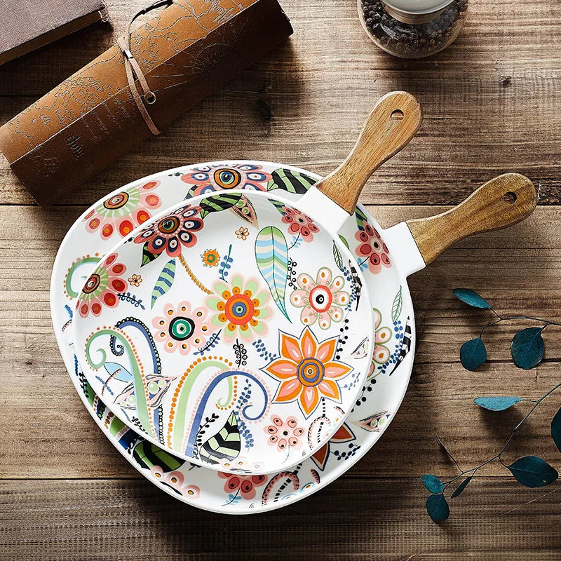 Decorative frying pan with floral patterns on a wooden surface