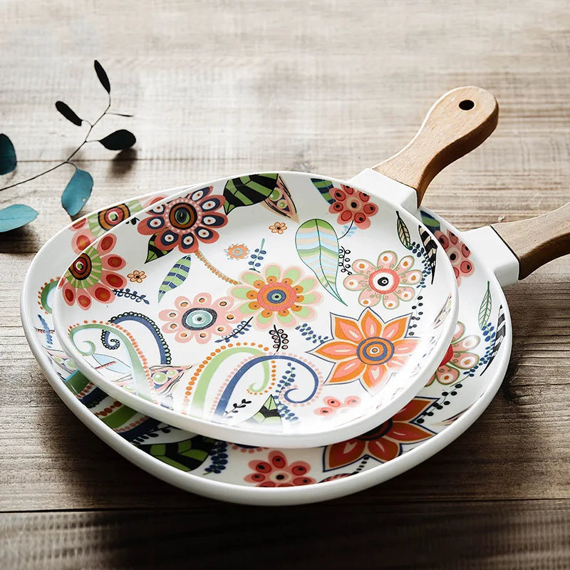 Decorative frying pan with floral patterns on a wooden surface