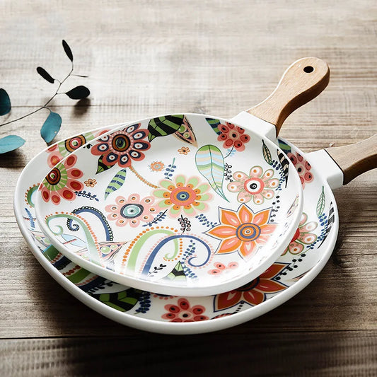 Decorative frying pan with floral patterns on a wooden surface